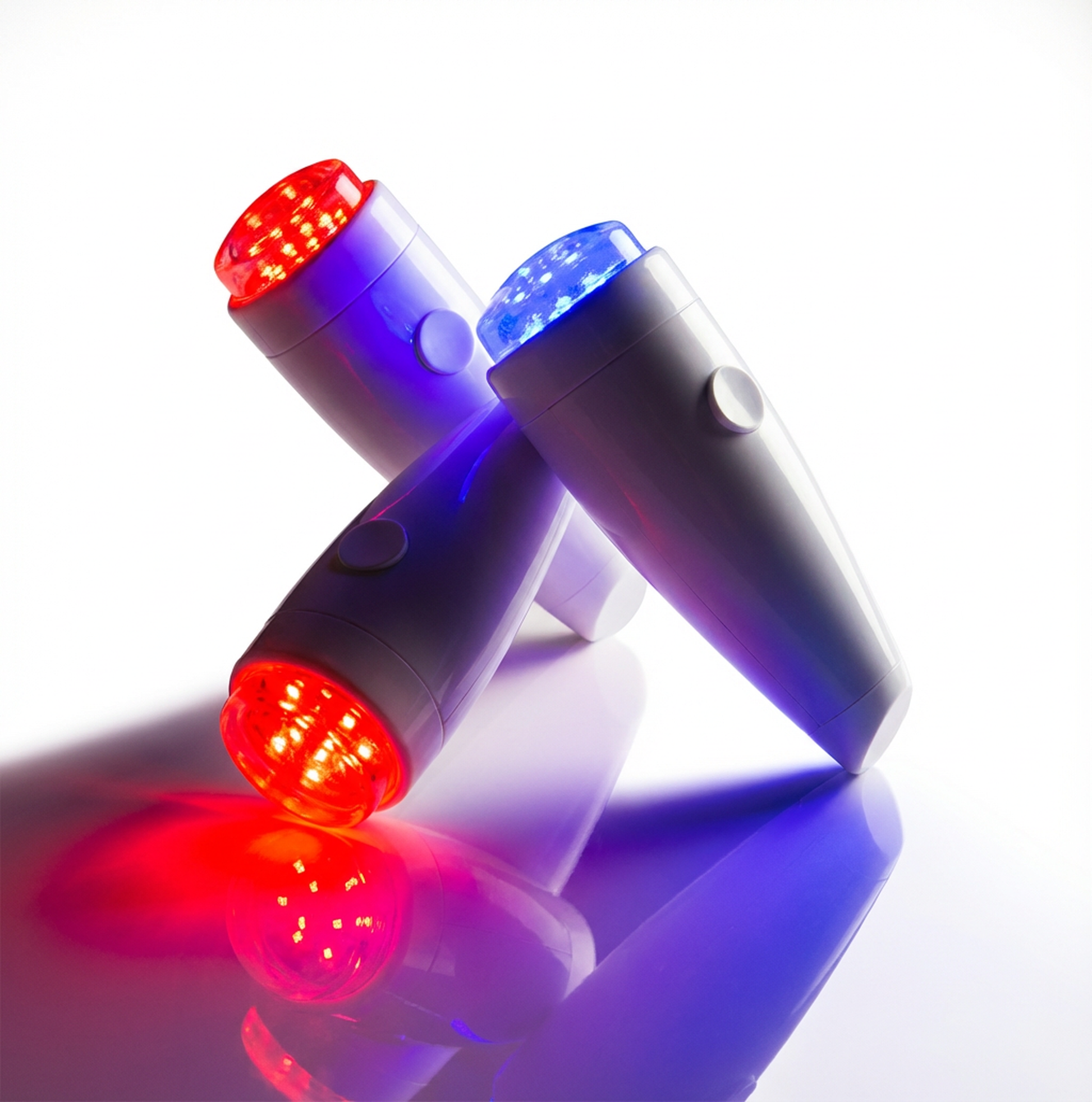 Three LED lights emitting red and blue light on a reflective surface.